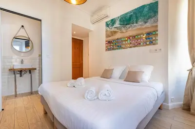 a bedroom with a white bed with towels on it at Agences des Résidences - Rue Commandant André in Cannes