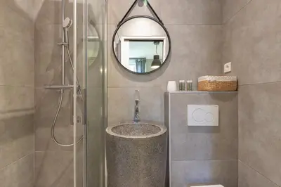 a bathroom with a shower with a sink and a mirror at Agences des Résidences - Rue Commandant André in Cannes