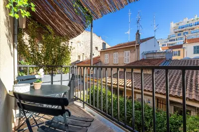 a patio with a table and chairs on a balcony at Agences des Résidences - Rue Commandant André in Cannes