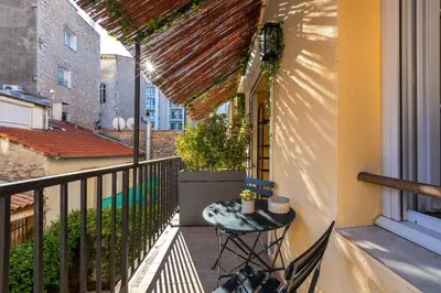 a balcony with a table and chairs on a balcony at Agences des Résidences - Rue Commandant André in Cannes