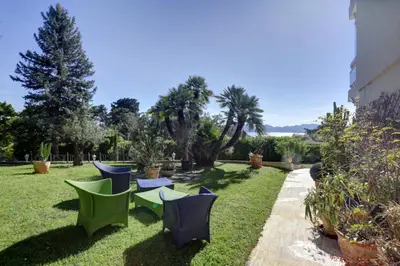 a group of chairs and tables in a yard at Appartement - villa Le Saint Georges avec superbe jardin et vue mer panoramique in Cannes