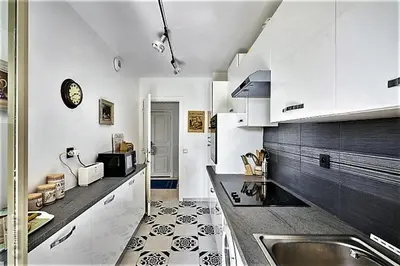 a kitchen with a sink and a counter top at Appartement - villa Le Saint Georges avec superbe jardin et vue mer panoramique in Cannes