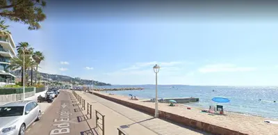 a beach with cars parked next to the water at Fettolina Palm Beach, Location Cannes front de mer et plage in Cannes