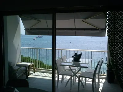 a table and chairs on a balcony with a view of the ocean at Fettolina Palm Beach, Location Cannes front de mer et plage in Cannes