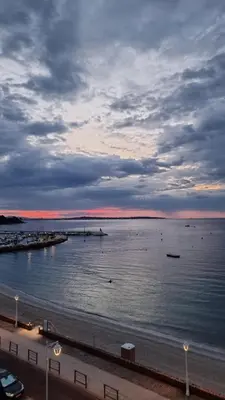 a large body of water with a beach and a cloudy sky at Fettolina Palm Beach, Location Cannes front de mer et plage in Cannes