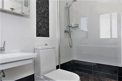 a white bathroom with a toilet and a shower at Fettolina Palm Beach, Location Cannes front de mer et plage in Cannes