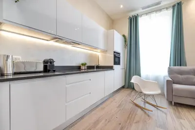 a kitchen with white cabinets and a chair at Résidence Montaigne - Luxurious - 350m Palais - LRA Cannes in Cannes