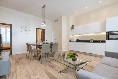 a kitchen and living room with a table and chairs at Résidence Montaigne - Luxurious - 350m Palais - LRA Cannes in Cannes