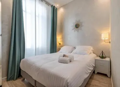 a bedroom with a large bed with towels on it at Résidence Montaigne - Luxurious - 350m Palais - LRA Cannes in Cannes