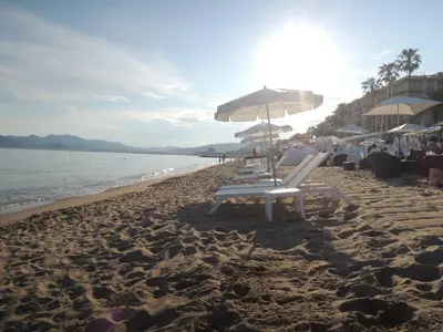 a group of chairs and umbrellas on a beach at Prime Location Hyper Center Ideal for Couples & Families - Walk Everywhere -By Totolulucannes in Cannes