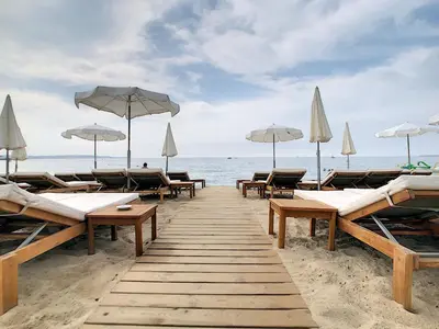 a beach with benches and umbrellas and the ocean at Prime Location Hyper Center Ideal for Couples & Families - Walk Everywhere -By Totolulucannes in Cannes