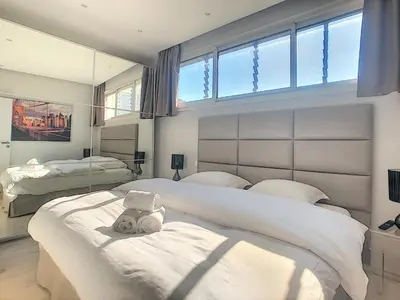 a bedroom with two beds and a large window at 24 Août Sucquet in Cannes
