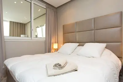 a bedroom with a large white bed with a hat on it at 24 Août Sucquet in Cannes