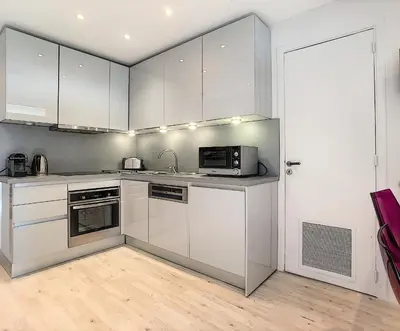 a kitchen with white cabinets and a microwave at 24 Août Sucquet in Cannes