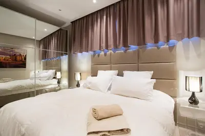 a bedroom with a large white bed and a large mirror at 24 Août Sucquet in Cannes