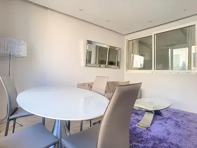 a dining room with a white table and chairs at 24 Août Sucquet in Cannes