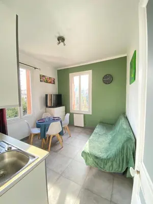 a kitchen with a sink and a room with a table at Appartement PALOMA Proche Cannes in Le Cannet