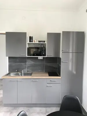 a kitchen with white cabinets and a sink at Appartement PALOMA Proche Cannes in Le Cannet