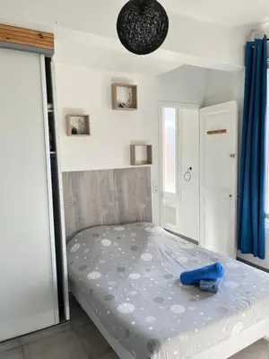 a bed in a room with a blue object on it at Appartement PALOMA Proche Cannes in Le Cannet