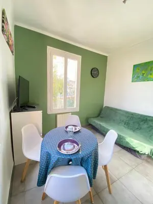 a room with a table and chairs and a bed at Appartement PALOMA Proche Cannes in Le Cannet