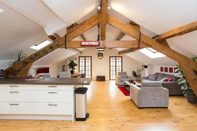 an attic kitchen and living room with exposed beams at LB Vacation Rentals I Big Loft 107m2, 10min Walk to Palais des Festivals in Cannes