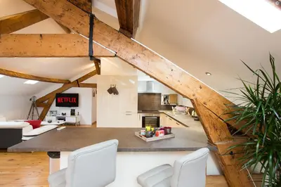 an attic kitchen and living room with wooden beams at LB Vacation Rentals I Big Loft 107m2, 10min Walk to Palais des Festivals in Cannes