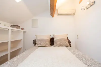 a bedroom with a bed with pillows on it at LB Vacation Rentals I Big Loft 107m2, 10min Walk to Palais des Festivals in Cannes