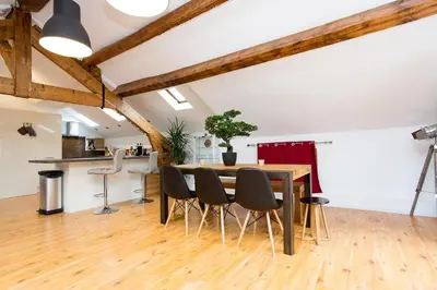 a kitchen and dining room with a wooden table and chairs at LB Vacation Rentals I Big Loft 107m2, 10min Walk to Palais des Festivals in Cannes