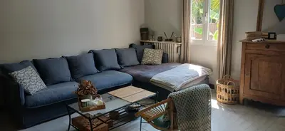 a living room with a blue couch and a table at Au fil de l eau in Cannes