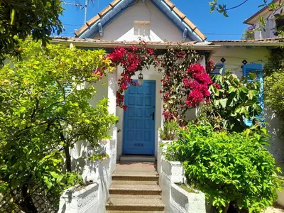 a white house with a blue door and flowers at Au fil de l eau in Cannes