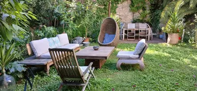 a garden with a couch and a hammock and a table at Au fil de l eau in Cannes