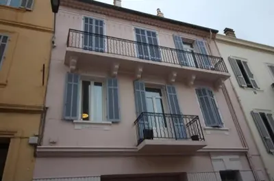 a building with blue windows and balconies on it at Cosy apartment in Cannes