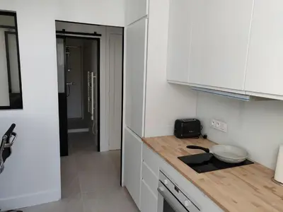 a kitchen with white cabinets and a counter top at Cosy apartment in Cannes