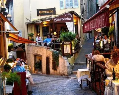 a group of people sitting at tables outside a restaurant at Cosy apartment in Cannes