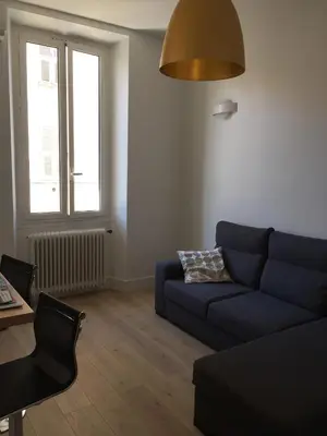 a living room with a blue couch and a window at Cosy apartment in Cannes