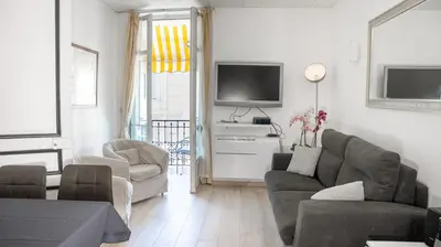 a living room with a couch and a tv at Central Cannes, 200m to Palais, walk everywhere in Cannes