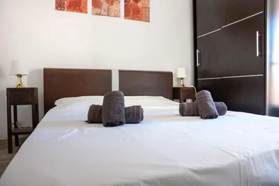 a large white bed with some pillows on it at Central Cannes, 200m to Palais, walk everywhere in Cannes