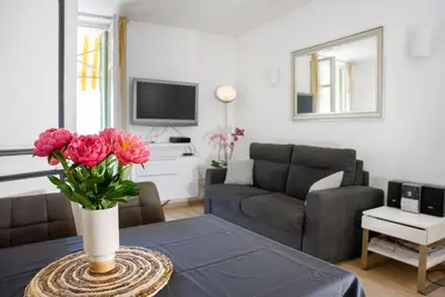 a living room with a vase of flowers on a table at Central Cannes, 200m to Palais, walk everywhere in Cannes