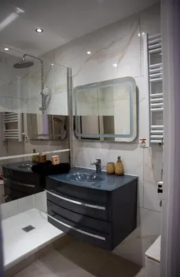 a bathroom with a sink and a large mirror at Central Cannes, 200m to Palais, walk everywhere in Cannes