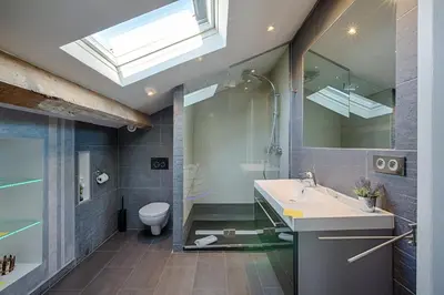 a bathroom with a sink and a toilet and a skylight at RG Duplex - Sea View - Palais & Croisette - Luxury Stay by LRA Cannes in Cannes
