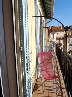 a red chair sitting on a balcony at RG Duplex - Sea View - Palais & Croisette - Luxury Stay by LRA Cannes in Cannes