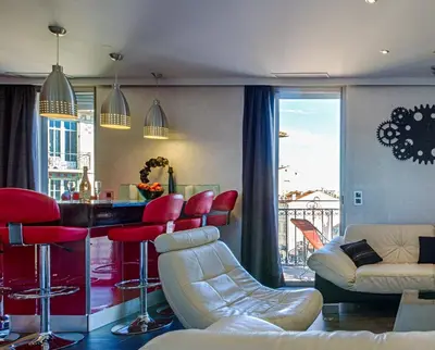 a living room with a bar with red chairs at RG Duplex - Sea View - Palais & Croisette - Luxury Stay by LRA Cannes in Cannes