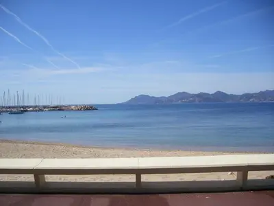 a bench sitting on a beach next to the water at Karolina Properties - Appartement Commodore Croisette in Cannes