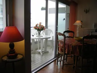 a dining room with a table with a vase of flowers at Karolina Properties - Appartement Commodore Croisette in Cannes