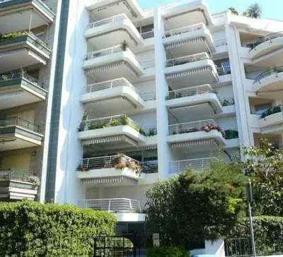 a large white apartment building with balconies and plants at Karolina Properties - Appartement Commodore Croisette in Cannes