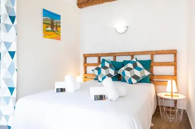 a bedroom with a bed with blue and white pillows at Résidence Le Suquet in Cannes