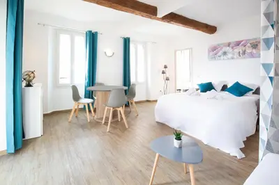 a bedroom with a bed and a table and chairs at Résidence Le Suquet in Cannes