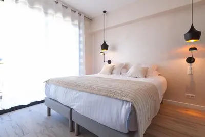 a bedroom with a large bed with white sheets and pillows at Residence Provencal - Luxurious - 300m Palais - LRA CANNES in Cannes
