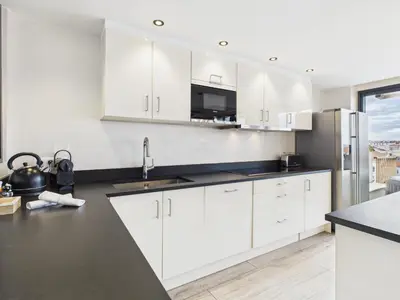 a kitchen with white cabinets and a black counter top at Residence Provencal - Luxurious - 300m Palais - LRA CANNES in Cannes