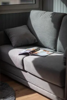 a couch with a book on the arm of it at Belle surprise cœur de ville, cosy avec terrasse in Cannes